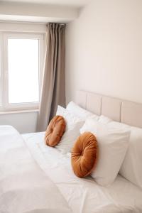 two brown pillows sitting on a white bed at Luxurious Suite - Train Station Deinze in Deinze