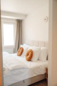 a white bed with two orange pillows on it at Luxurious Suite - Train Station Deinze in Deinze +4 photos