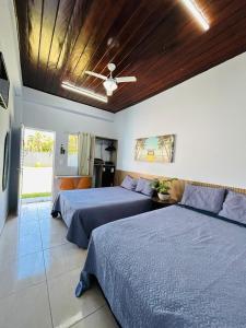 a bedroom with two beds and a ceiling fan at IMPERIAL BEACH ENSEADA 500 Metros Praia Enseada Gjá Av Professor João Batista Julião x Antonio Del Nero Enseadas jardim Virgínia Bairro Nobre in Guarujá
