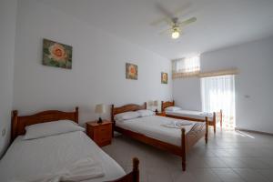 a bedroom with two beds and a ceiling fan at Vida House in Borsh +9 photos