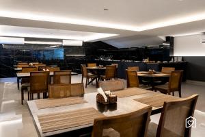 a restaurant with wooden tables and chairs and a bar at Edifício MOVE Novo- Tambaú in João Pessoa