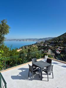 a table and chairs on a balcony with a view of the water at Mesaiz in Vlorë