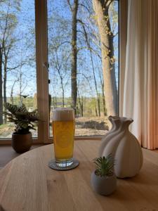 a glass of beer sitting on a table with a vase at WaldQuartier in Memmelsdorf