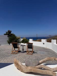 a pair of chairs and a table on a roof at SeaBreeze Milos in Mytakas