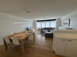 a kitchen and living room with a table and chairs at C-Blanche in Blankenberge