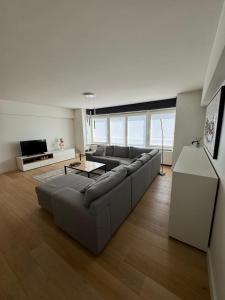 a living room with a couch and a table at C-Blanche in Blankenberge