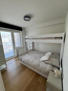 a bedroom with two bunk beds and a wooden floor at C-Blanche in Blankenberge