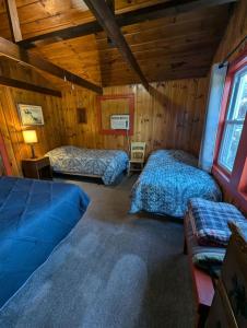 a bedroom with two beds in a log cabin at 2BR 1BA Cabin #8 at Riverside Point Resort in Park Rapids +67 photos