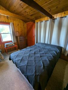 a bedroom with a large bed in a cabin at 2BR 1BA Cabin #8 at Riverside Point Resort in Park Rapids