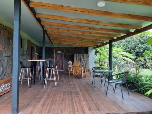 a wooden deck with chairs and tables on a house at Hotel Uka Mana in Hanga Roa