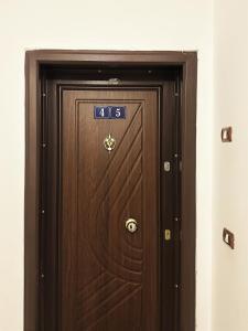 a wooden door with the number on it at DuoNest Gray Loft Studio in Tirana