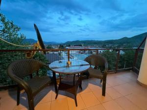 a table and chairs on a balcony with a view at Paradiso 5 in Bratunac