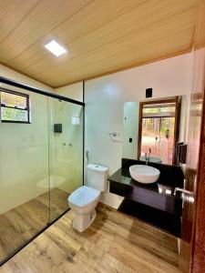 a bathroom with a toilet and a sink and a shower at Tiny House Londres, Timbó in Timbó +4 photos