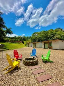four colorful chairs sitting in a gravel yard at Tiny House Londres, Timbó in Timbó