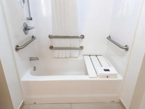 a bathroom with a bathtub and towel racks at Garner Hotel Pecos by IHG in Pecos