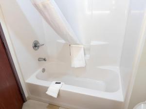 a bathroom with a white tub and a sink at Garner Hotel Pecos by IHG in Pecos