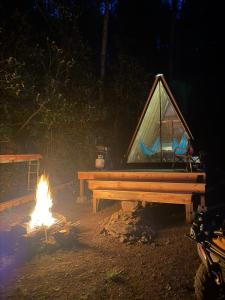 a tent sitting next to a fire with a campfire at The Outside Inn in Cullowhee