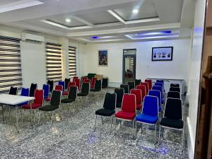 a room with chairs and tables and blue and red chairs at Chinbell Luxury Hotel & Suites in Lekki