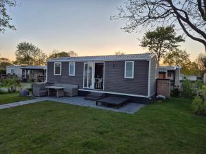 a tiny house with a patio in a yard at Chalet Duin & Zee 44, Renesse in Renesse