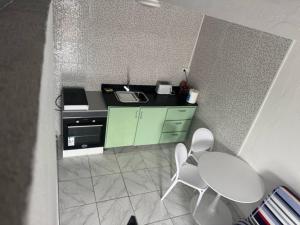 eine kleine Küche mit einem Tisch und weißen Stühlen in der Unterkunft SCi 3I in Cayenne