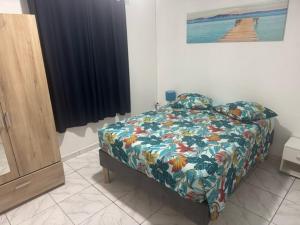 ein Schlafzimmer mit einem Bett mit einer farbenfrohen Bettdecke in der Unterkunft SCi 3I in Cayenne