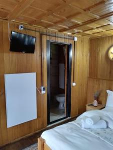 a room with a bed and a tv and a toilet at Casa de vacanta 1001 De Nopti in Corbşori +64 photos