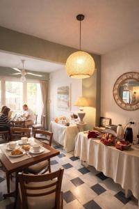 a dining room with two tables and people sitting at tables at Hotel Centro SJ in Villa Carlos Paz