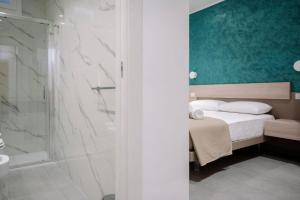 a bedroom with a bed and a glass shower at Orizzonte Blu in Villa San Giovanni
