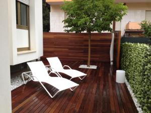 two white chairs and a tree on a deck at La Villetta in Giulianova