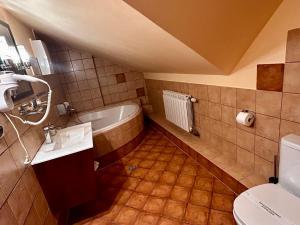 a bathroom with a tub and a sink and a toilet at Hotel LOKIS in Niedzica Zamek +90 photos