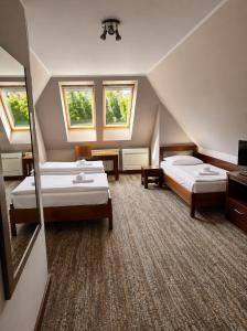 a hotel room with two beds and two windows at Hotel LOKIS in Niedzica Zamek
