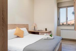 a bedroom with two beds and a desk and a window at Brummana Views in Broummana