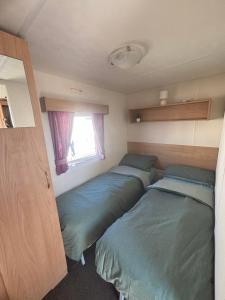 two beds in a small room with a window at S-M Statics in Kinmel Bay