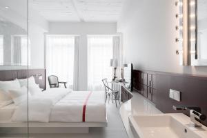 a white bedroom with a bed and a sink at Ruby Coco Hotel Dusseldorf by IHG in Düsseldorf