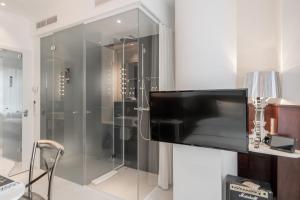 a bathroom with a shower with a flat screen tv at Ruby Coco Hotel Dusseldorf by IHG in Düsseldorf