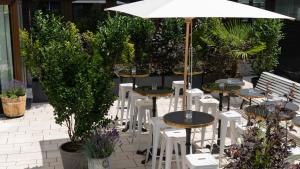 a patio with tables and chairs and an umbrella at Ruby Coco Hotel Dusseldorf by IHG in Düsseldorf +55 photos