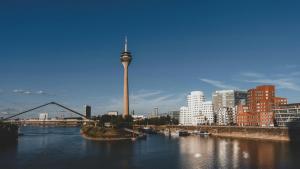 a view of a city with a tower in the water at Ruby Coco Hotel Dusseldorf by IHG in Düsseldorf