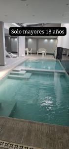 a swimming pool with green water in a building at Apartamentos El Fortín in San Salvador de Jujuy