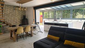 a living room with a couch and a table and a kitchen at Maison de village in Copponex