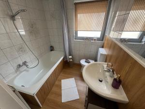 a bathroom with a sink and a tub and a toilet at BOHO Apartment Skye in Bad Reichenhall +24 photos