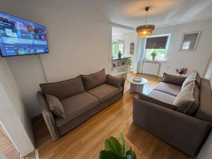 a living room with two couches and a flat screen tv at BOHO Apartment Skye in Bad Reichenhall