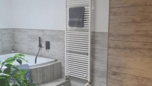 a bathroom with a white tub and a wooden wall at Feriendomizil Sasse in Wusterwitz