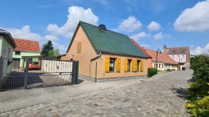 a house with a green roof and a fence at Feriendomizil Sasse in Wusterwitz