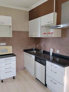 a kitchen with white cabinets and a sink at Gure Bidetxe in San Andrés