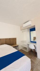 a bedroom with a bed and a desk and a chair at Hotel Plaza del Ángel in Huajuapan de León