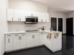 a kitchen with white cabinets and a microwave at TinyHouseMX1 Comodidad y playa que se disfruta in San Patricio Melaque