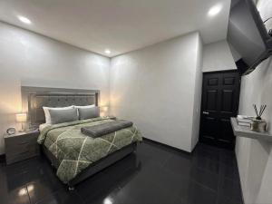 a bedroom with a bed with a green blanket at TinyHouseMX1 Comodidad y playa que se disfruta in San Patricio Melaque