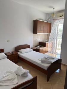 a room with two beds and a kitchen at Vila Riviera in Ksamil