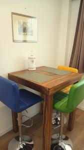 a wooden table with colorful chairs around it at NaturalmenteLucia 2 in Cologno al Serio