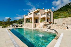 a villa with a swimming pool and a house at La Dolce Rustica - Hillside Villa in Sutomore